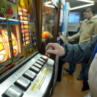 Varias personas gastan dinero en máquinas tragaperras en un local destinado a las apuestas y juegos de azar.-ICAL