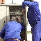 Dos instaladores eléctricos trabajan en un cuadro de control.-ISRAEL L. MURILLO