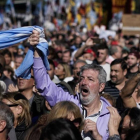 Un hombre empuña la bandera argentina entre la multitud que ha tomado las calles de Buenos Aires para protestar por la situación económica del país.-VICTOR R. CAIVANO (AP)