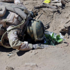 Un soldado iraquí reza ante la tumba de uno de los militares masacrados por el Estado Islámico en el 2014.-REUTERS