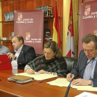 El consejero de la Presidencia, en primer término, estampa su firma en el acuerdo. A su derecha, Carmen Ámez (UGT) y Carlos Hernando (CSIF).-Ical