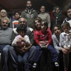 Dimitris Spiridis (en primera fila, tercero por la izquierda), junto a su mujer, Maria, y varios miembros de las dos familias sirias que acoge en su casa, en Evropos, cerca de Idomeni, este lunes.-REUTERS / ALEXANDROS AVRAMIDIS