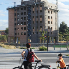 Una mujer y un niño  pasan por delante de un edificio en obras.-ISRAEL L. MURILLO