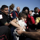 Una niña siria es ayudada a bajar de su embarcación en la isla griega de Lesbos, este sábado.-LKIS KONSTANTINIDIS
