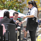 Una camarera cobra a los clientes de una terraza ubicada en el casco histórico de Burgos .-ISRAEL L. MURILLO