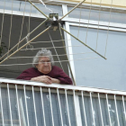 Una mujer mayor asomada a la terraza de su vivienda en la capital burgalesa.-ISRAEL L. MURILLO
