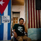 El cubano Armando Ricart Batista, actor y exboxeador, posa ante la bandera cubana y retratos de los Castro en su casa de la Habana.-RAMÓN ESPINOSA / AP