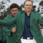 Jordan Spieth se enfunda la chaqueta verde de manos de Bubba Watson, vencedor en el 2014.-Foto: REUTERS / BRIAN SNYDER