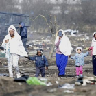 Refugiadas caminan con sus hijos por el campamento de Calais durante su desmantelamiento.-EFE / ARCHIVO