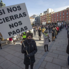 Una persona sostiene un cartel exigiendo compensaciones económicas durante una protesta contra los cierres de hostelería decretados por la Junta. S. OTERO