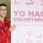 Un joven sostiene un cartel que promociona el voluntariado. ECB