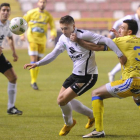 El defensa de la Arandina Garcés agarra de la camiseta a  Fito Miranda, autor del segundo gol capitalino.-ISRAEL L. MURILLO