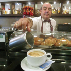 Un camarero sirve un café con leche a un cliente.-QUIQUE PALA