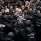 Agentes de la policía nacional intentan desalojar a las personas concentradas en las puertas del colegio Ramon Llull de Barcelona el 1-O.-FERRAN NADEU