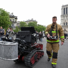 Un bombero, junto con el robot que ayudó a los bomberos en el incendio de Notre Dame, este martes.-REUTERS / YVES HERMAN