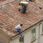 Dos hombres trabajan en la reparación de un tejado sin ningún tipo de sujeción.-ISRAEL L. MURILLO