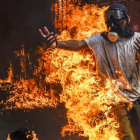 Un manifestante entre llamas después de estallar el depósito de la moto de un policía durante una protesta contra el presidente Maduro en Caracas.-JUAN BARRETO