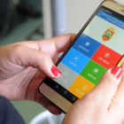 Una mujer consulta la aplicación Burgos al móvil que integra el servicio 010.-ISRAEL L. MURILLO