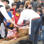 Un grupo de niños observa con atención como se realiza el despiece del cerdo.-ISRAEL L. MURILLO