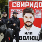 Varias personas pasan junto a un póster electoral del partido nacionalista Rodina (Patria), en Moscú, este jueves.-AP / PAVEL GOLOVKIN