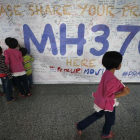 Un grupo de niños escribiendo mensajes esperanzadores para los familiares de las personas que desaparecieron en el vuelo MH370, de la compañía Malasya Airlines, en mayo del 2014.-AP / WONG MAYE-E (AP)
