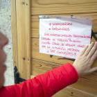 Una mujer coloca un cartel avisando del cierre del establecimiento. RAÚL OCHOA