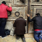 Peregrinos rezan en al puerta del Santo Sepulcro, cerrado.-/ AP / MAHMOUD ILLEAN