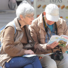 Dos turistas consultan una guía de la Comunidad.-ISRAEL L. MURILLO