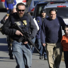 Agentes de policía custodian a padres e hijos de la escuela de Newtown tras la matanza del 2012.-AP / JESSICA HILL
