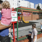 Un padre con su hijo y otros niños observan desde el exterior la guardería donde se exige que no se cierre.-SANTI OTERO