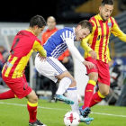 Bautista, de la Real, pelea un balón entre dos jugadores del Lleida.-EFE / GORKA ESTRADA