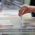 Una ciudadana introduciendo su voto en la urna.-