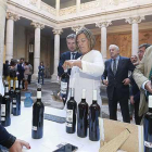 La consejera Milagros Marcos acompañada por el alcalde de Burgos y el subdelegado de la Junta en Burgos observan vinos en un puesto.-RAÚL G. OCHOA