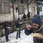 Refugiados comen en el exterior de un almacén abandonado en Belgrado.-MSF / MARKO DROBNJAKOVIC