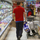 Un empleado repone género en un expositor refrigerado de lácteos, uno de los artículos de mayor consumo en la cesta de la compra, en la que la marca burgalesa Campofrío es una de las más consumidas.-RAÚL OCHOA
