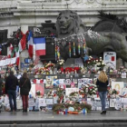 Homenajes a las víctimas en varios puntos de París. Sobre estas líneas, la placa conmemorativa en las antiguas oficinas de 'Charlie Hebdo'. A la derecha, un lector del último número de la revista en Niza.-REUTERS / CHARLES PLATIAU / ERIC GAILLARD / AP / CHRISTOPHE ENA / EFE / BENOIT TESSIER