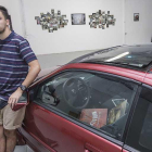 Jaime Uvedoble, junto al coche que ocupa el centro de la sala que acentúa el carácter urbano de la colección que viste las paredes.-Santi Otero