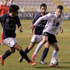 Armiche, que volverá a ser titular, protege el balón ante dos adversarios.-SANTI OTERO