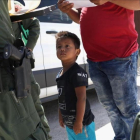 Un niño y sus padres, procedentes de Honduras, son retenidos por una patrulla policial cerca de la frontera de EEUU con México en Misión (Tejas), el 12 de junio pasado.-JOHN MOORE