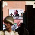 Un soldado custodia un centro de voto con un cartel electoral de Al Sisi.-AFP / KHALED DESOUKI