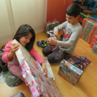 Dos hermanos disfrutan abriendo sus regalos de Reyes.-ECB