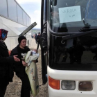 Dos mujeres se disponen a subir a un autocar en el campamento de Idomeni.-AFP / SAKIS MITROLIDIS