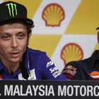 Valentino Rossi explica sus sensaciones antes del Gran Premio de Malasia, bajo la atenta mirada de Marc Márquez.-AP / JOSHUA PAUL
