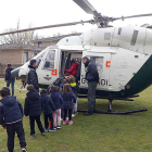 Un grupo de alumnos espera para subir a un helicóptero.-ECB