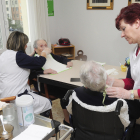 Dos trabajadoras ayudan a comer a dos ancianas. ISRAEL L. MURILLO