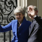 Theresa May junto a su marido Philip May saludan tras abandonar Downing Street.-AP / TIM IRELAND