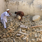 Dos niños afganos mueven los escombros de su vivienda, en el distrito de Nangarhar.-REUTERS / PARWIZ