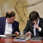 El 'president' Carles Puigdemont y el vicepresidente Oriol Junqueras conversan antes de la reunión del Govern de este martes.-FERRAN NADEU