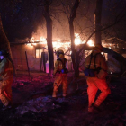 Bomberos en una casa en llamas en el sur de California.-AFP / MARK RALSTON