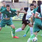 Pepe Delgado lucha por un balón con un jugador del Racing, ayer, en El Plantío.-ISRAEL L. MURILLO